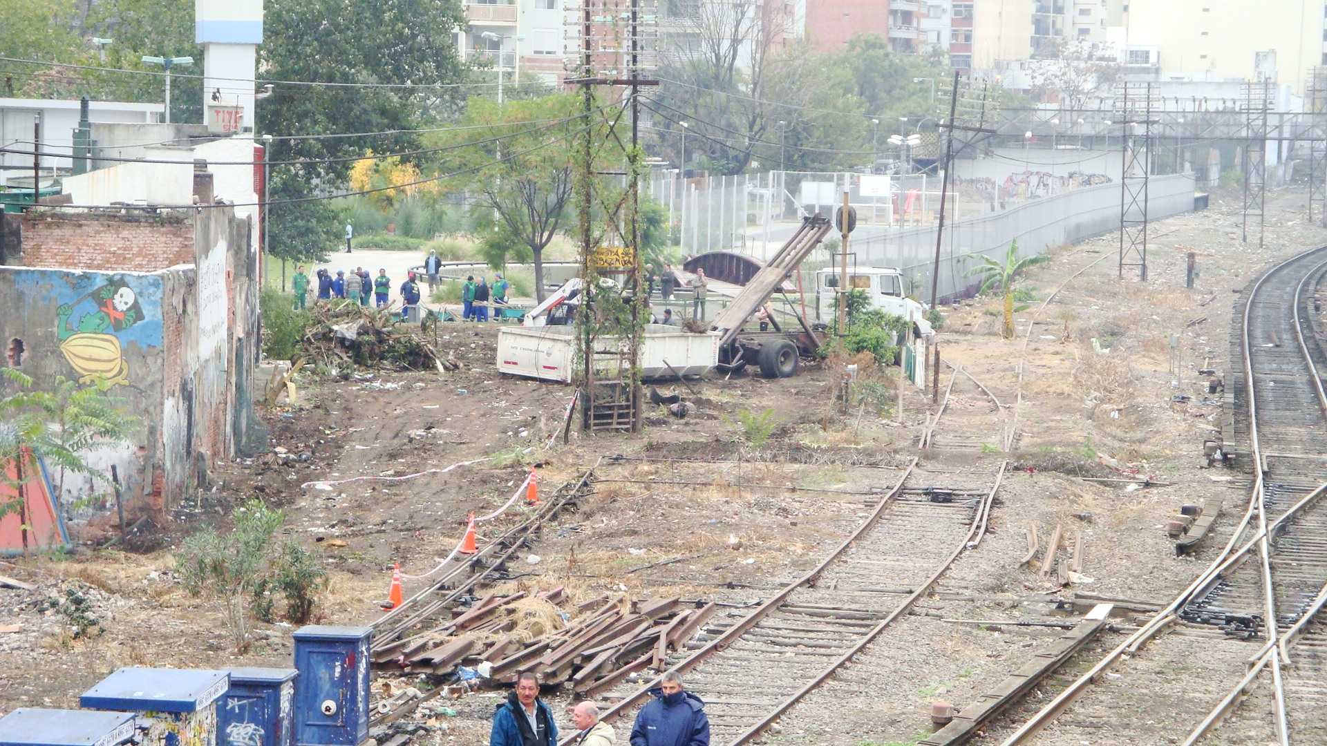 people walking on railroad tracks in a town