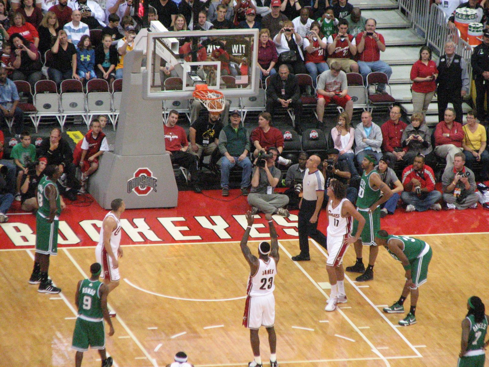 a bunch of people in the court playing a basketball game