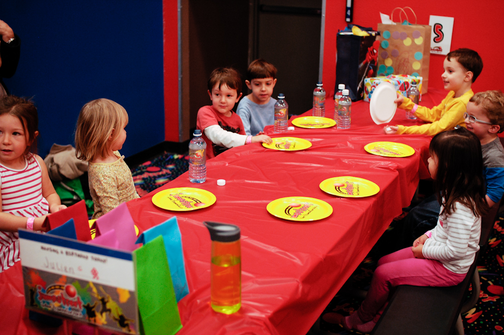 a group of s standing around a table with yellow plates on it