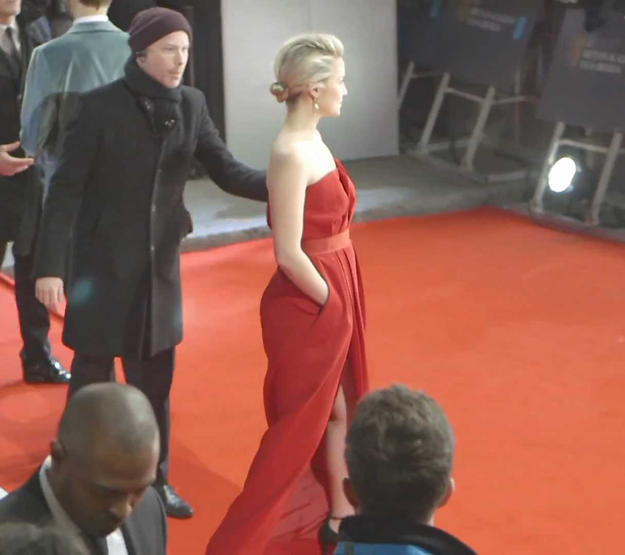 woman in red dress walking down the red carpet