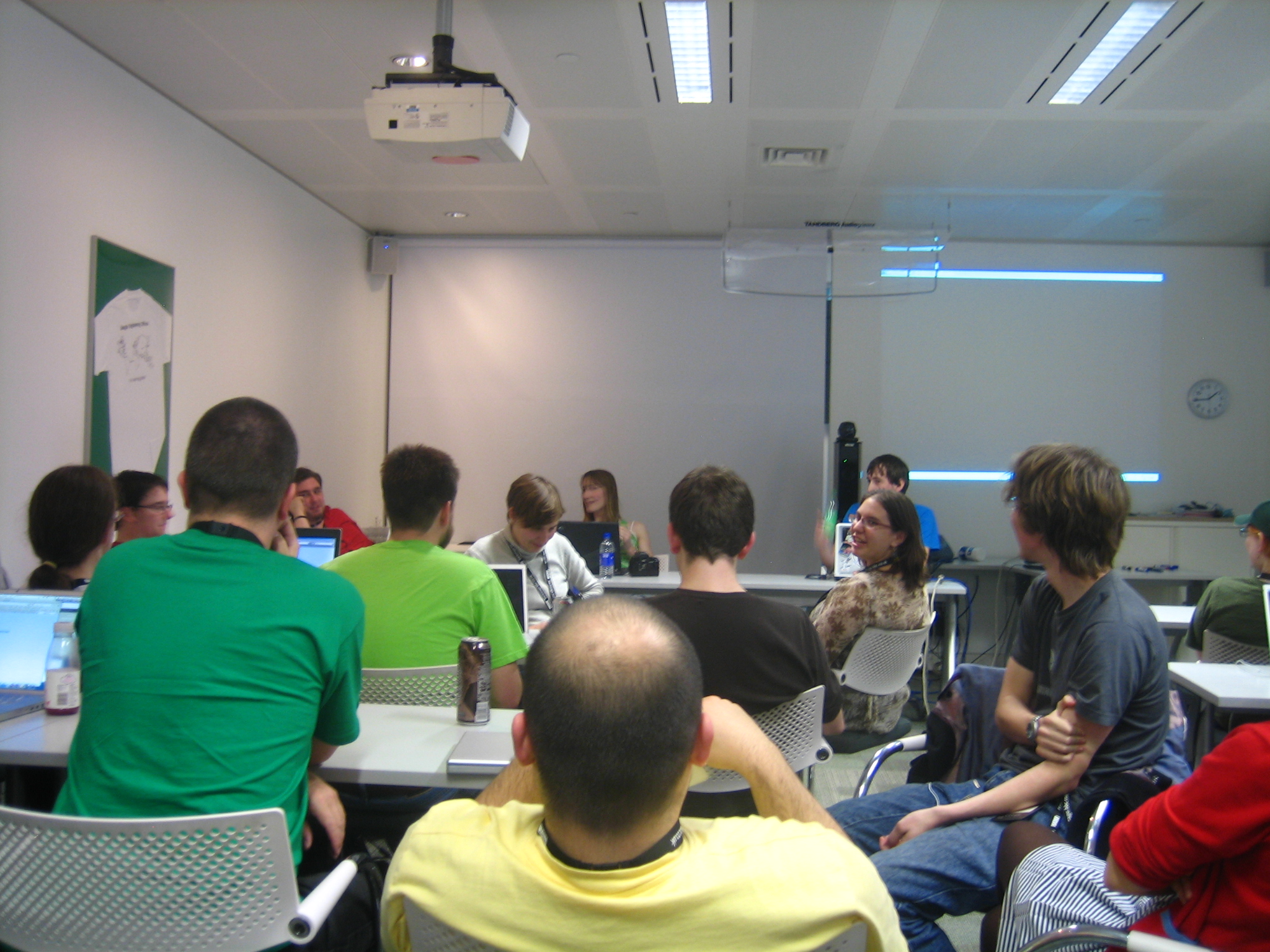 a group of people siting at desks and chairs in a classroom