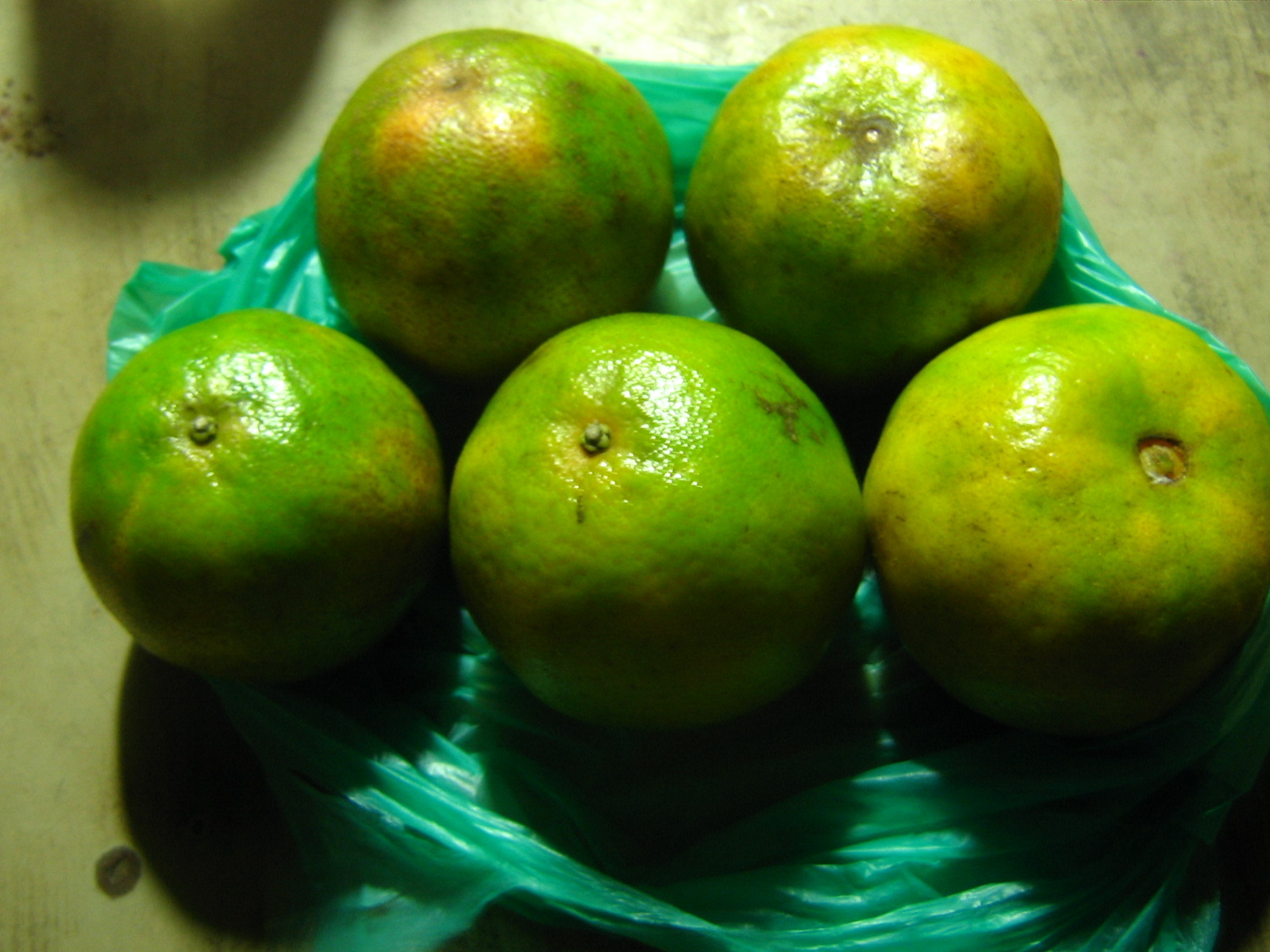 six green pears sitting in a plastic bowl