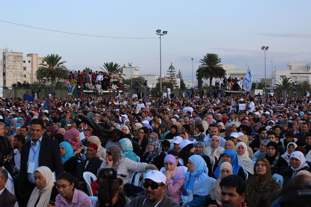 a crowd of people standing around each other