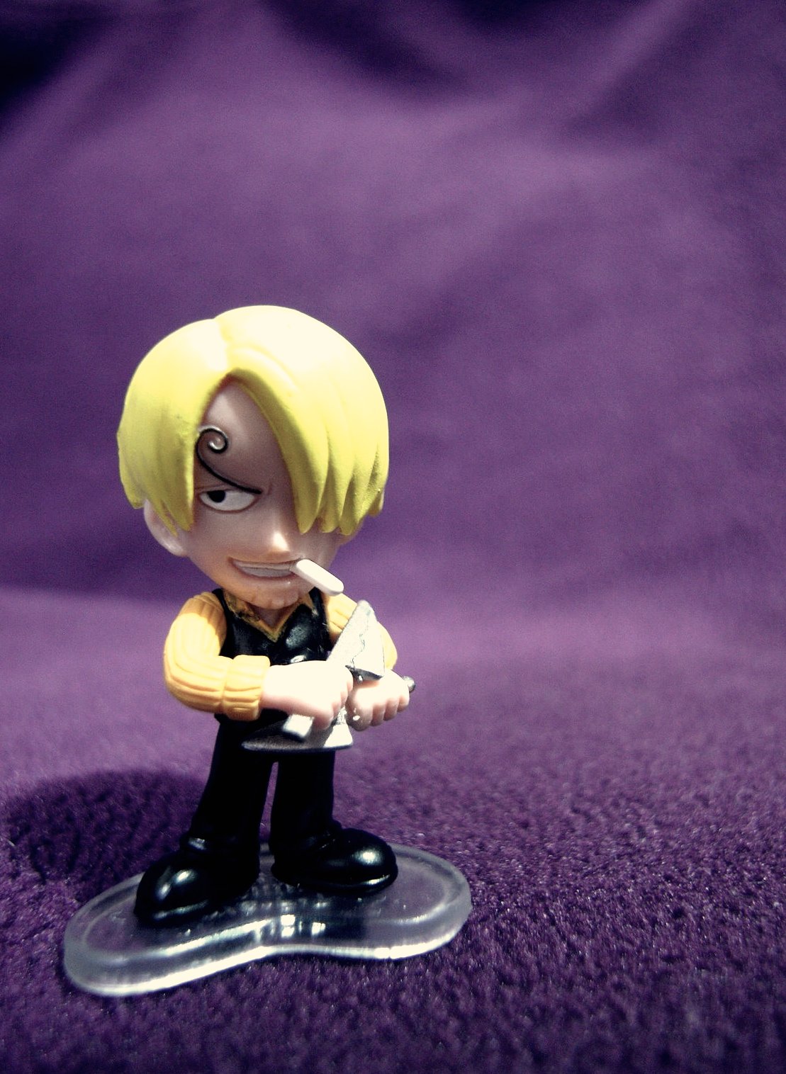 a toy figurine sitting on a purple surface