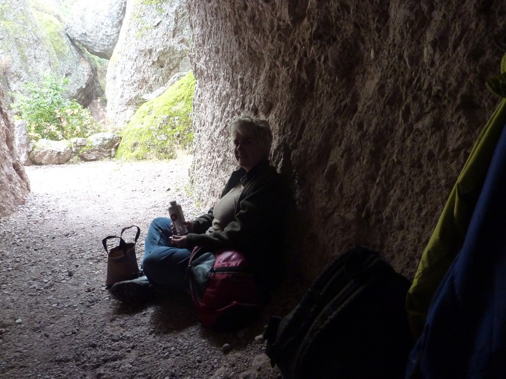 a woman sits on the ground next to two bags