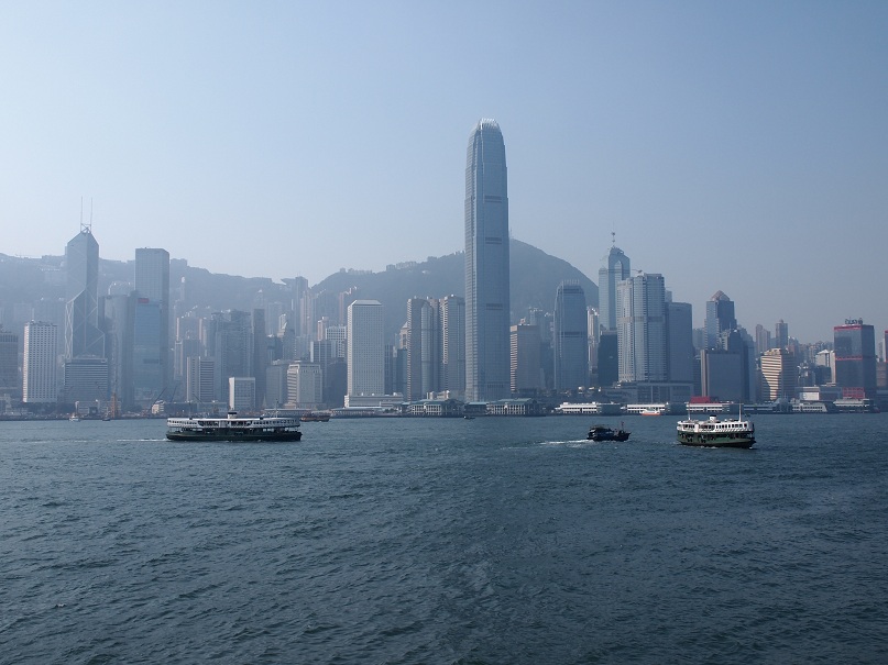 three boats are seen sailing in the harbor of hong kong