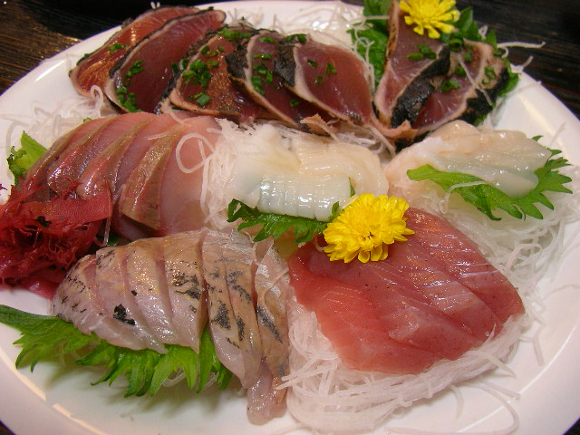 white plate of various kinds of sushi on top of a table