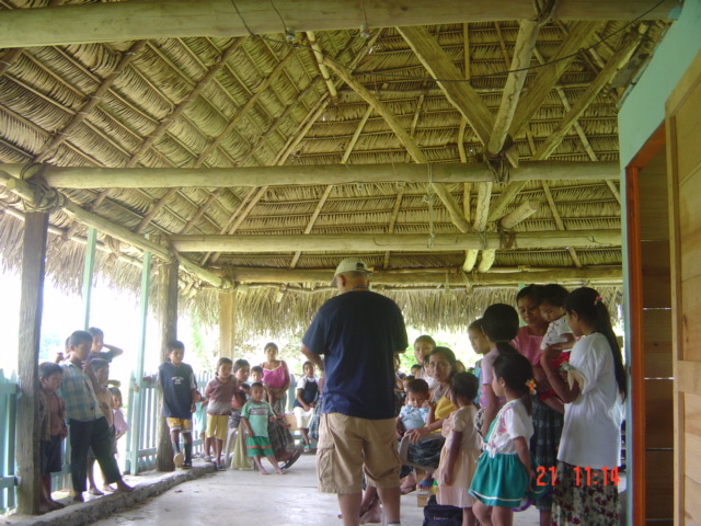 a group of people gather under a hut to watch