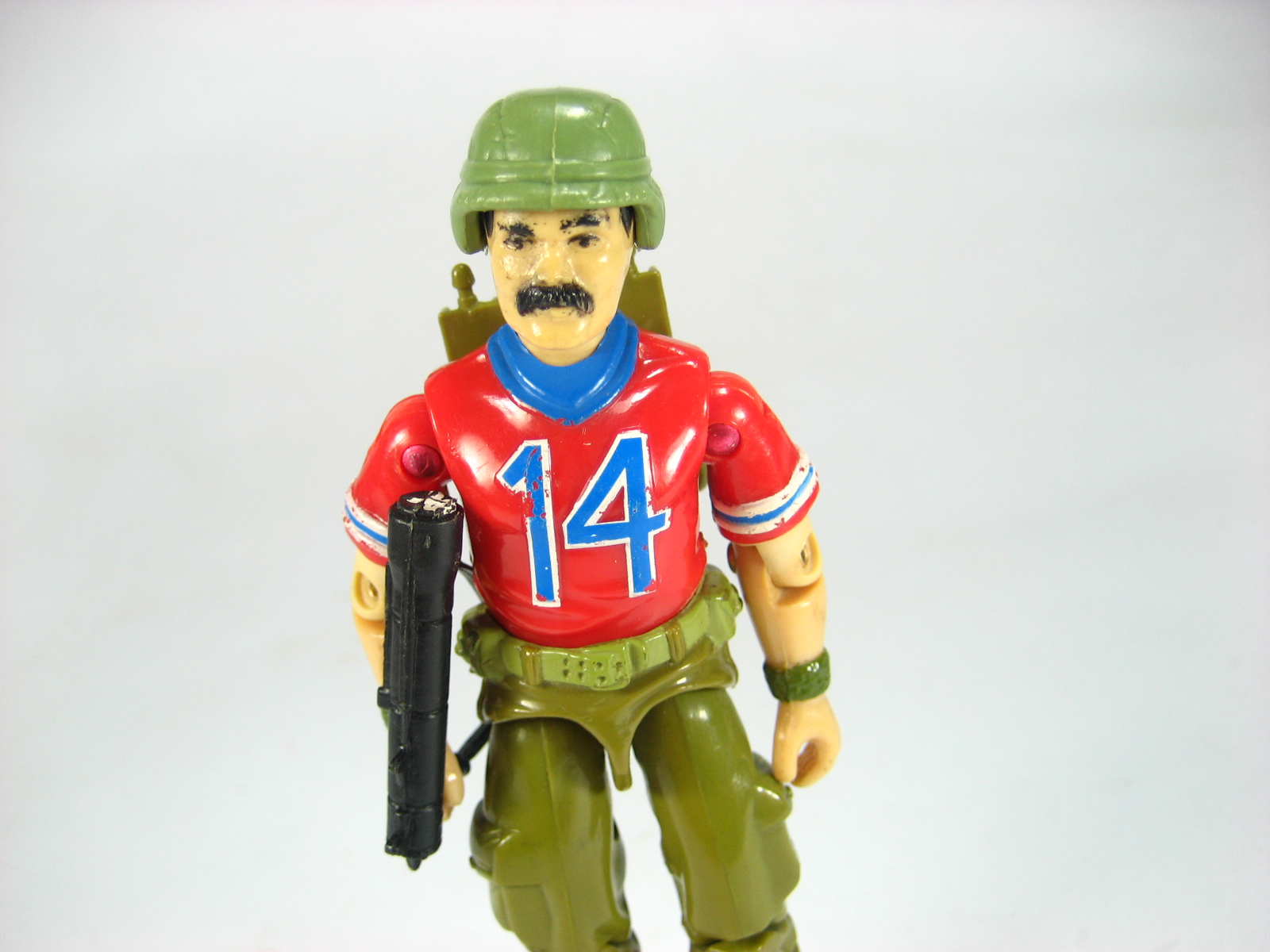 the toy is wearing a military uniform with a gun