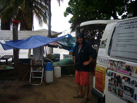a man stands in front of a van with an awning on top