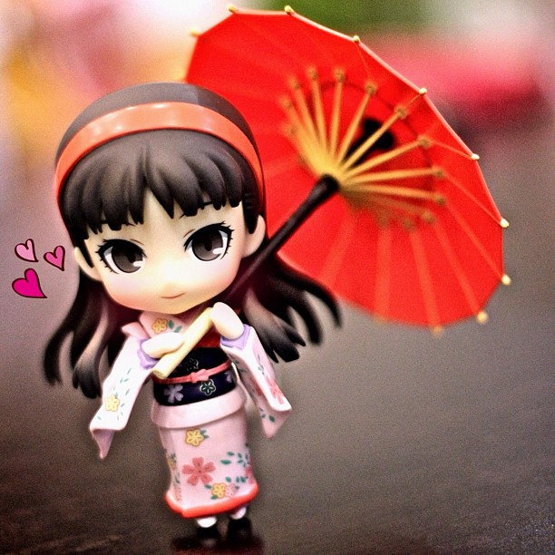 an anime doll with an umbrella on a table