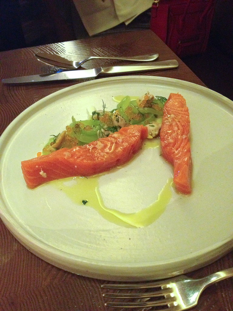 a piece of salmon on a white plate and fork