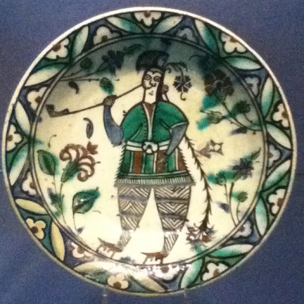 a decorative plate depicting a man holding two wands