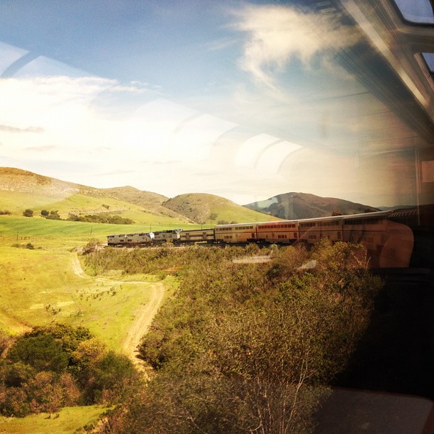 the view of the train going over a bridge in the countryside