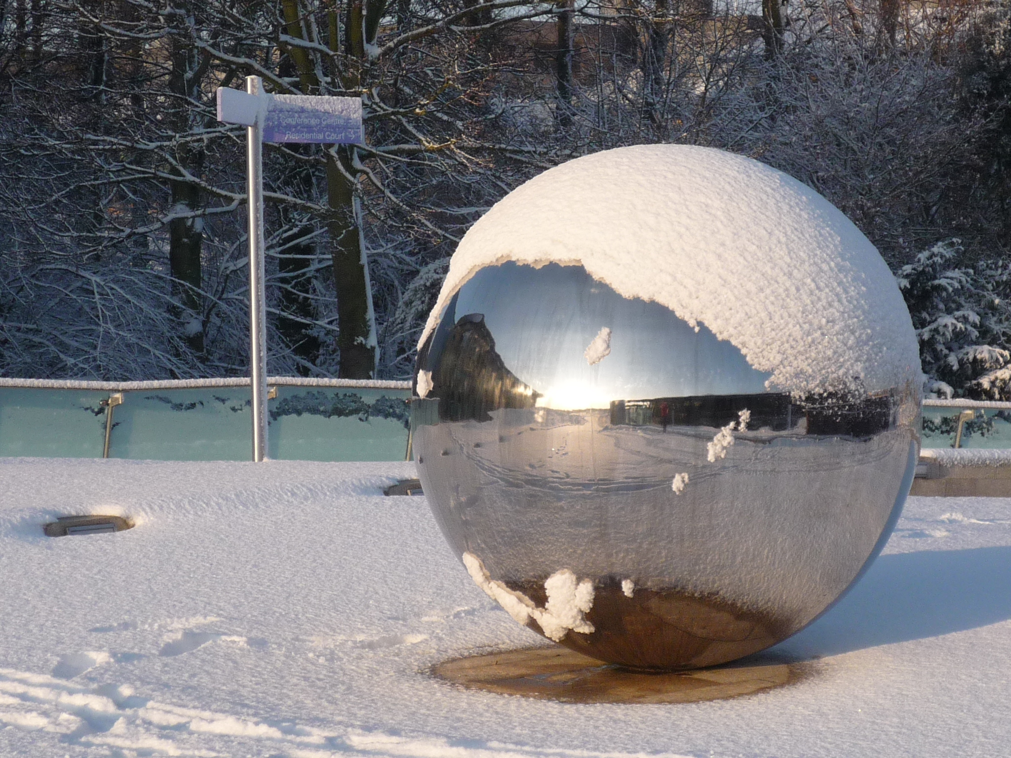a snow covered ball sits in front of a building