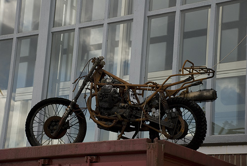 a dirt bike sits atop a large red container