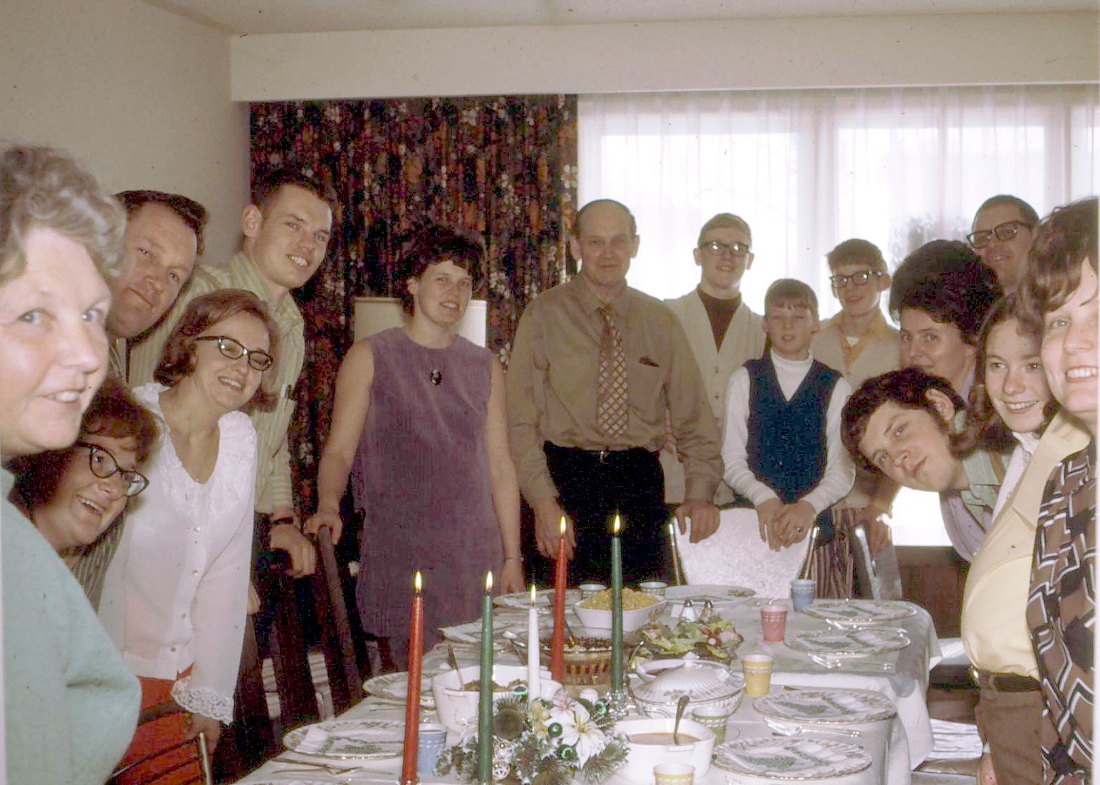 the group of people are posing in front of the birthday cake