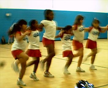 a group of girls dancing in the middle of a gym
