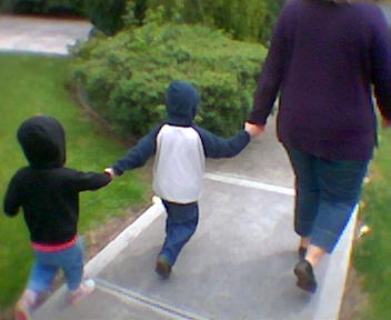 a young child holding the hand of his parent