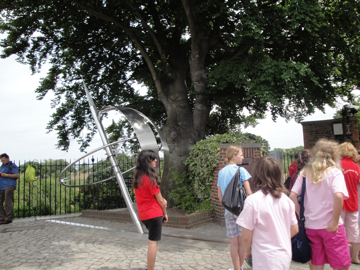 a group of people are observing an outdoor art project