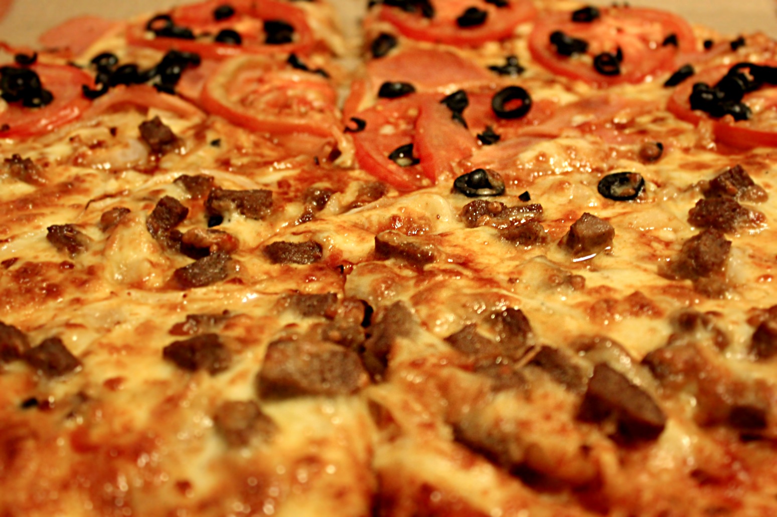 a pepperoni and sausage pizza on a counter