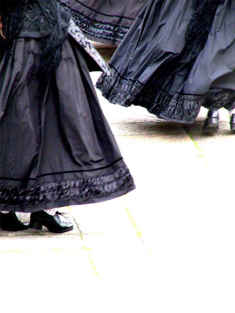 women are dancing and wearing dresses in the sun