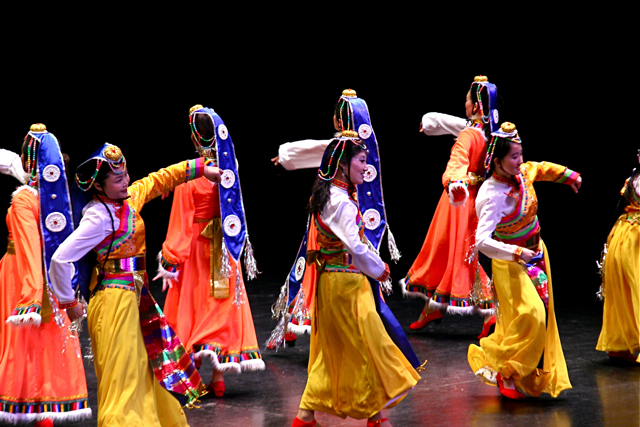 several people wearing colorful clothes and head dresses performing