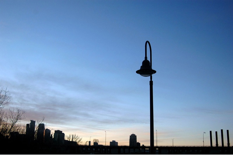 a lamp post in front of a very cloudy sky