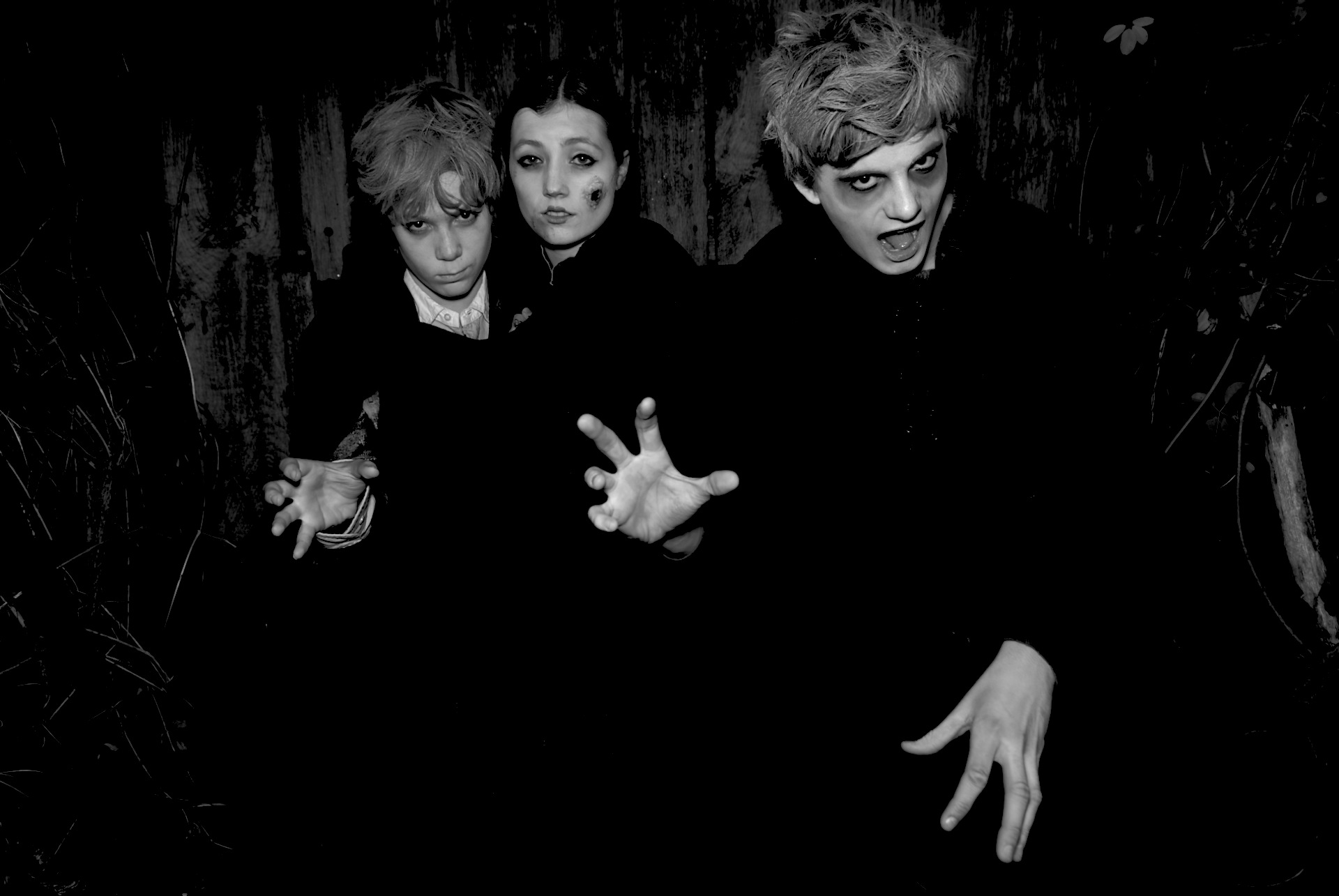three people with arms outstretched standing in a dark room