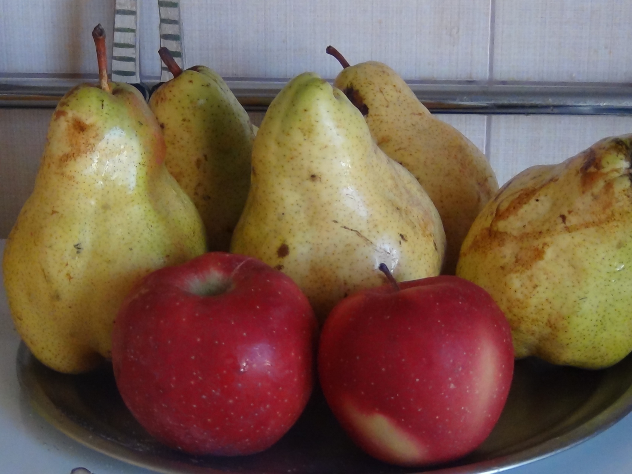 a variety of fruits displayed in a bowl on a kitchen scale