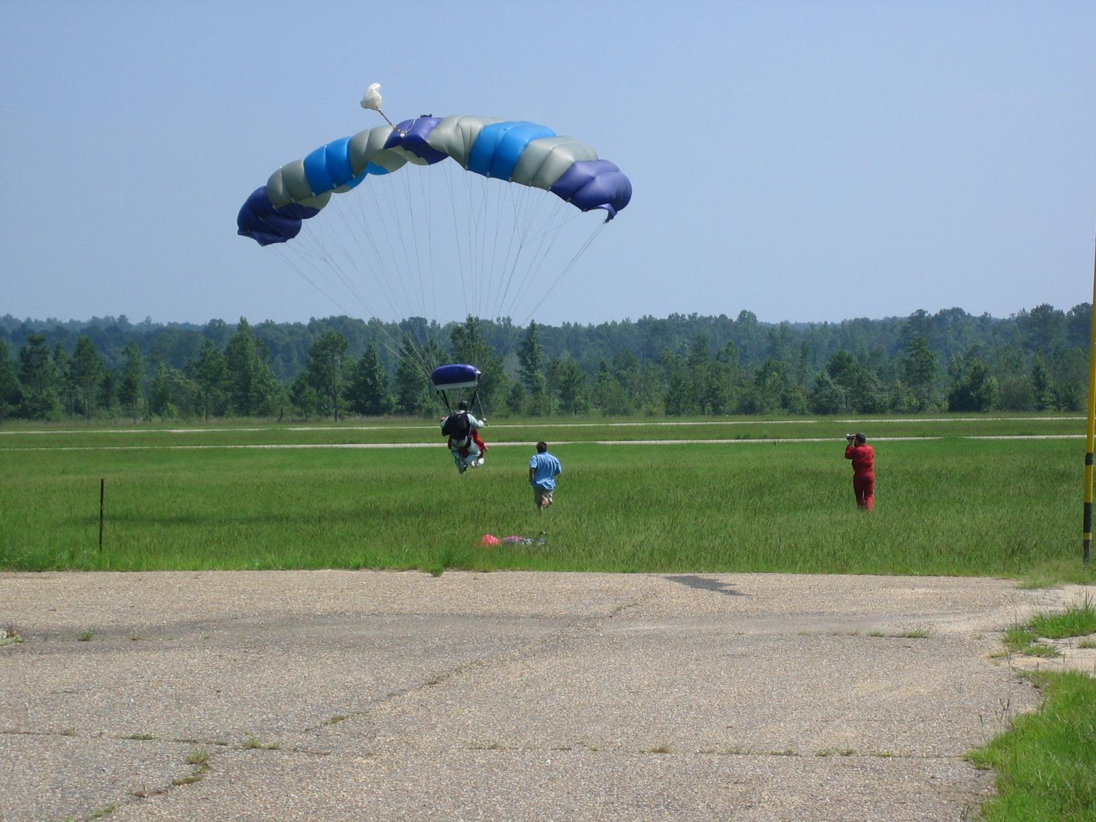 people are walking through an open field with some parachutes