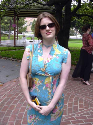 woman in colorful dress posing for camera, with people in background