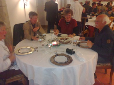 a group of people eating at a table with glasses