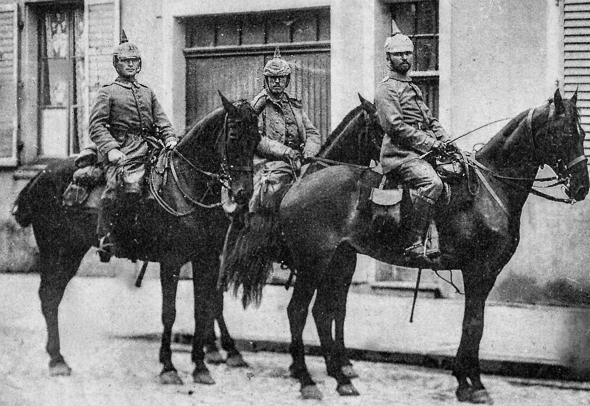 two men in uniforms riding on horses next to each other