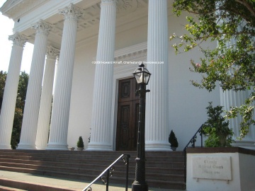 a column and steps leading to a large building