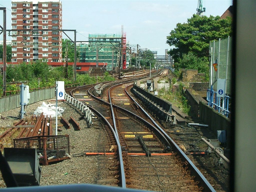 two sets of train tracks next to some buildings