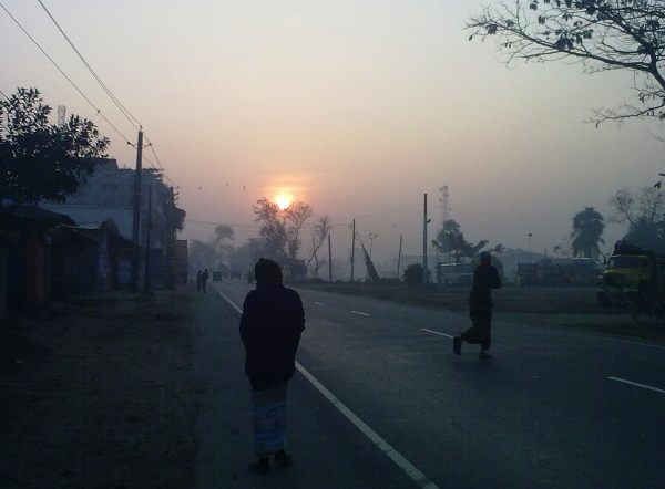 two men walking down the road at sunset