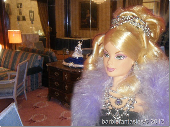 a barbie doll in a purple dress stands in the living room