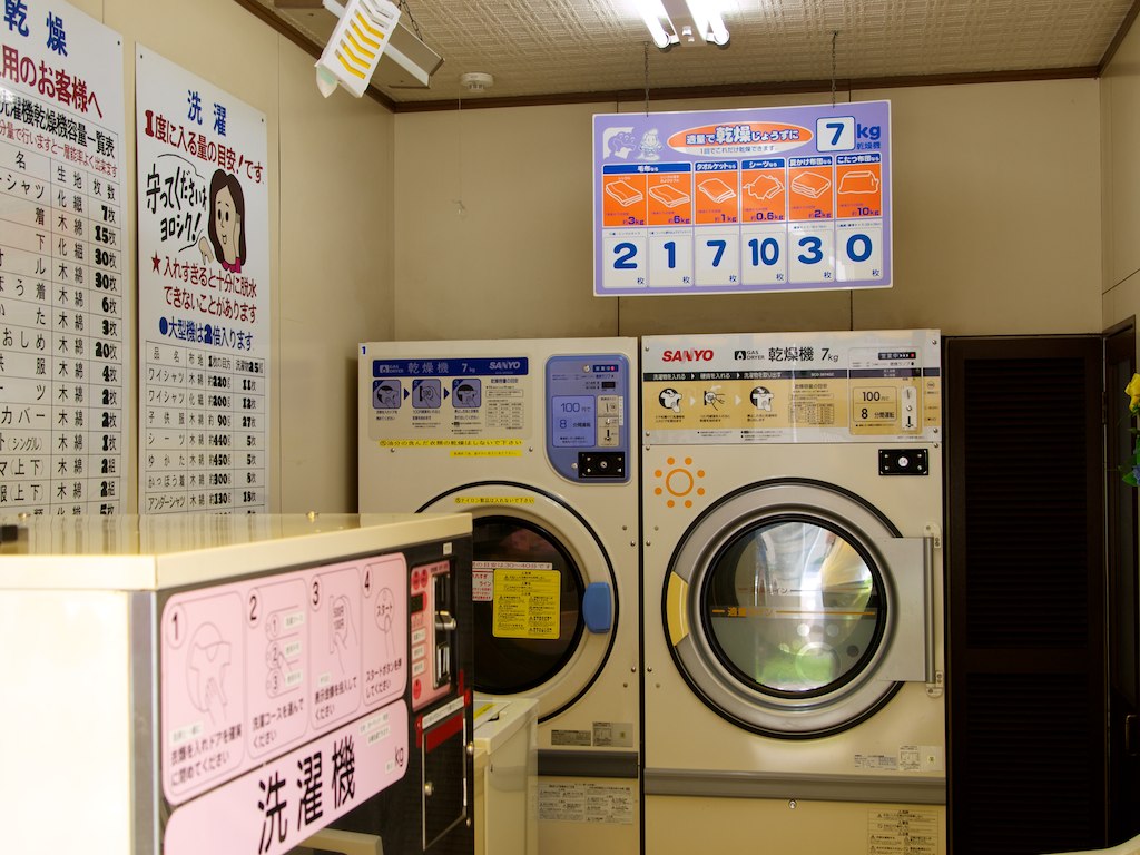 a washer and dryer inside a building with a sign