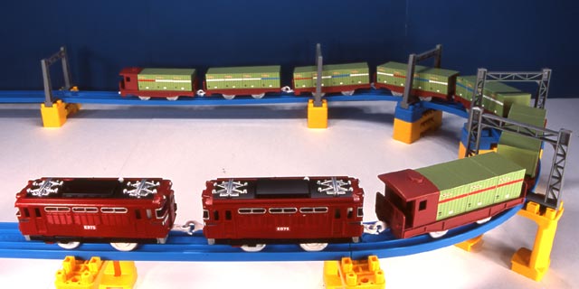 a toy train set in front of a blue wall