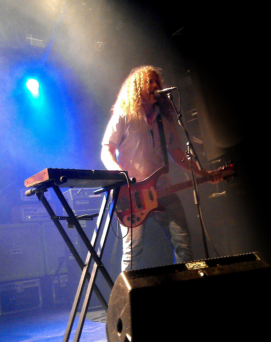 a man playing guitar on stage during the day