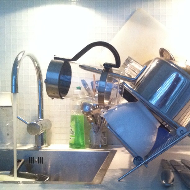 a kitchen with dishes stacked on the sink