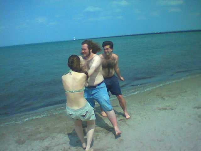 a group of young people playing frisbee on the beach