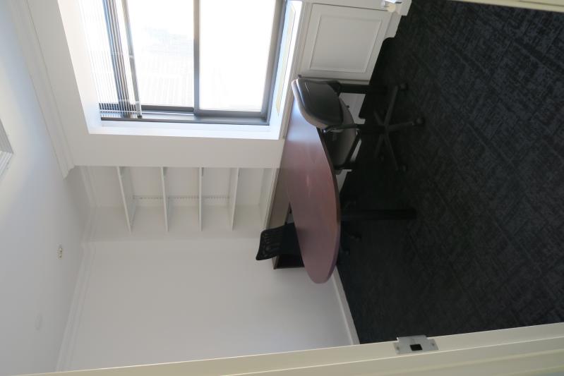 an empty office with desk, chair and window