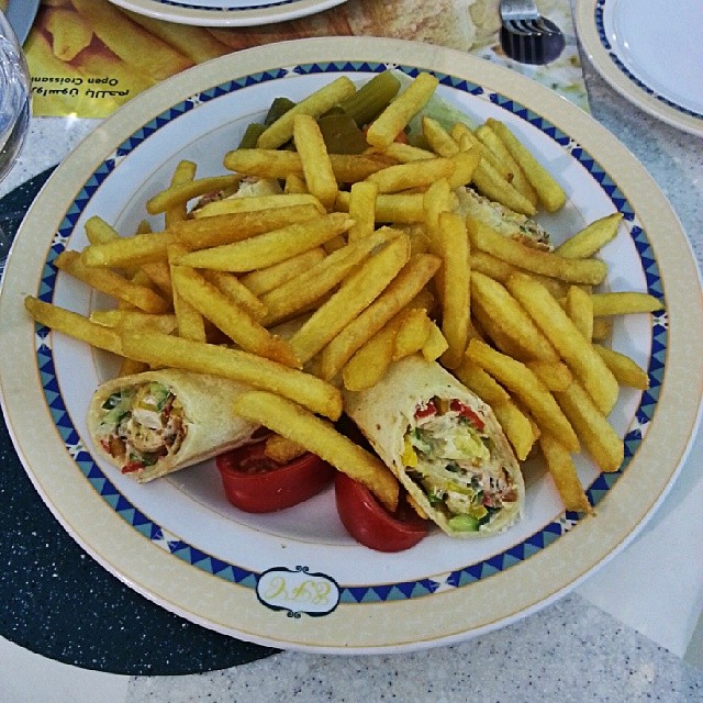 a sandwich and french fries on a blue and white plate