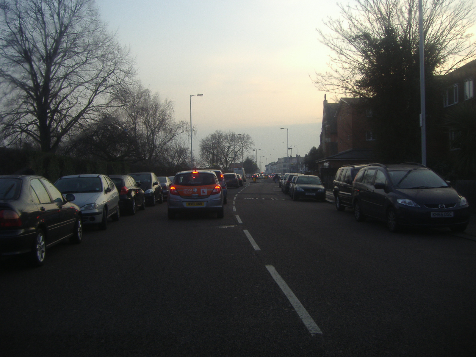 several cars are seen in a road, near one another