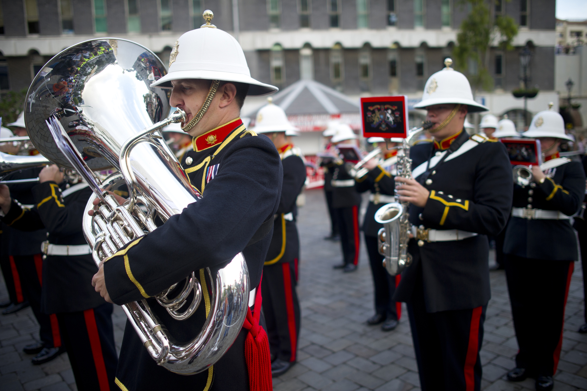 a marching band wearing hats and uniforms is playing instruments