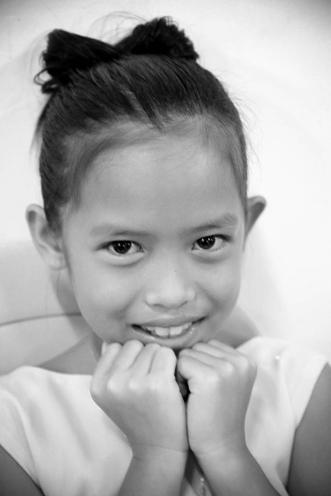 a little girl smiles brightly in a black and white po