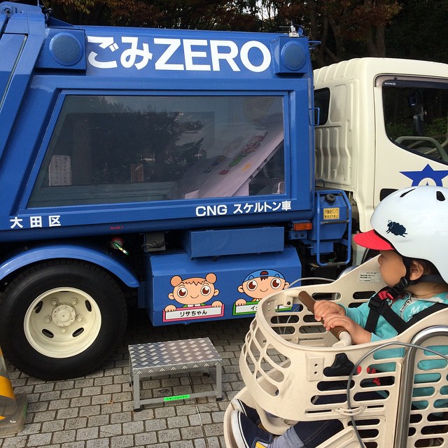 a child wearing a safety helmet sitting on a bench next to a truck