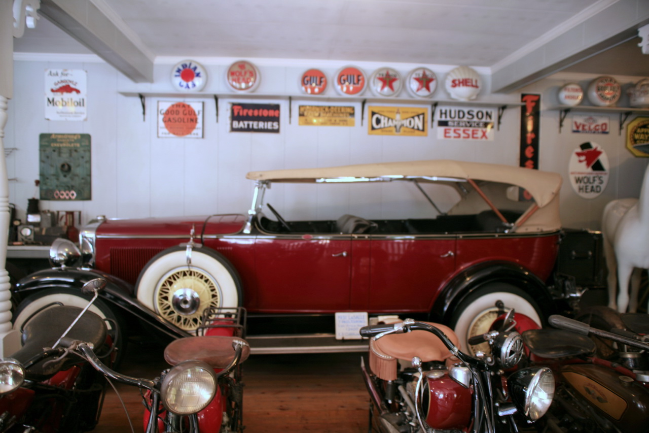 some antique cars parked in a garage next to other old cars